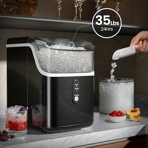 Countertop ice maker with ice and scooping hand.